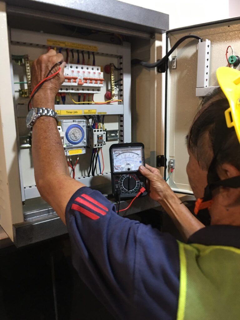 Hình ảnh kỹ thuật viên đang kiểm tra các kết nối điện tại tòa nhà