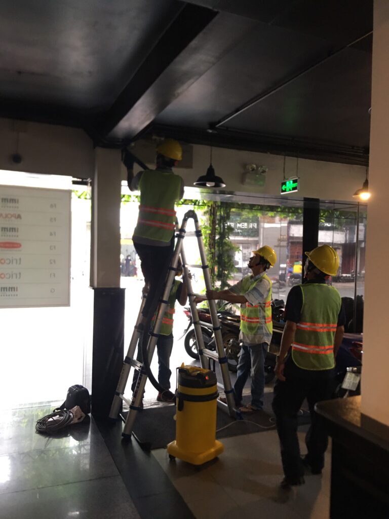 Kỹ thuật viên của VKCONS đang thực hiện kiểm tra và thay thế đèn chiếu sáng của tòa nhà